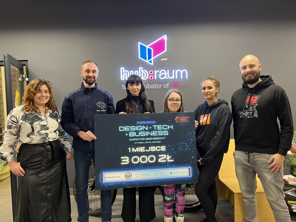 The winning team holding a check for PLN 3,000. The team consists of four women, two men, who are looking at the camera and smiling