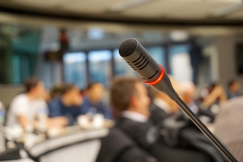 A decoartive element: a microphone and a blurred auditorium background