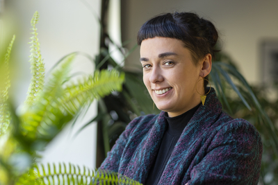 A young brunette woman with short hair among the greenery