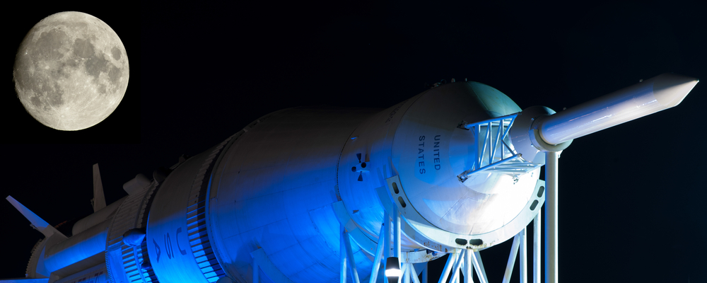 Saturn rocket lying horizontally. A large moon is visible above it.