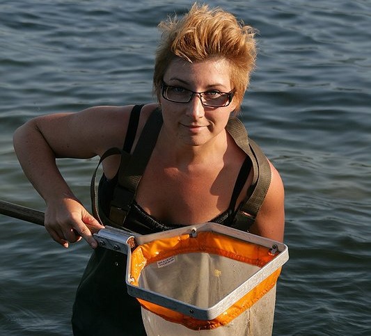 A woman with a fishing net in the water